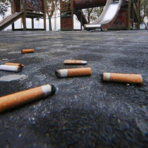mozziconi di sigarette per terra nella villa comunale di Napoli, sullo sfondo giostre per bambini. ANSA/CIRO FUSCO